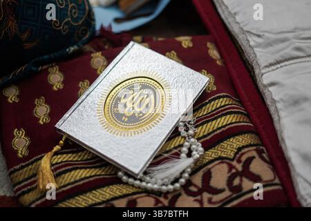 Der heilige Al Quran mit schriftlicher arabischer Kalligrafie, was Al Quran bedeutet Stockfoto