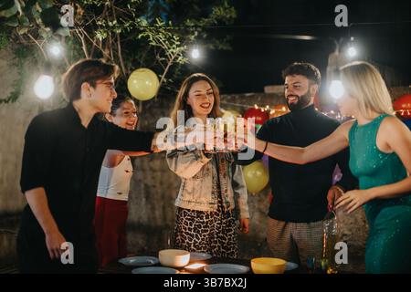 Freunde feiern auf einer festlichen Geburtstagsparty im Freien mit fröhlicher Dekoration Stockfoto