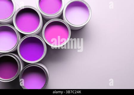 Dosen mit Farbe in Violetttönen auf weißem Hintergrund, Draufsicht. Leerzeichen für Text Stockfoto