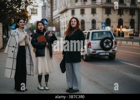 Drei stilvolle Personen, die tagsüber auf einer Straße interagieren Stockfoto