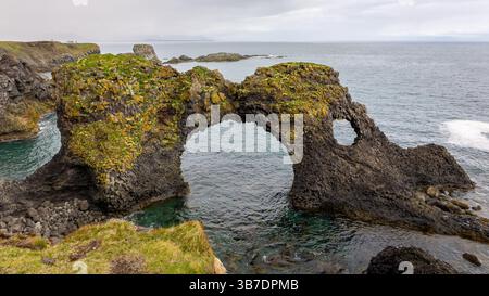Gatklettur, Felsformation in Form eines mit Moos bewachsenen Bogens, Seevögel nisten, Küste der Halbinsel Snaefellsnes in Island. Stockfoto