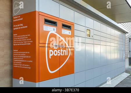 Ein orangefarbenes und graues PostNL Paket- und Brieffach in den Niederlanden, das 24/7 Postdienste bietet. Utrecht, Niederlande. 9. April 2025. Stockfoto