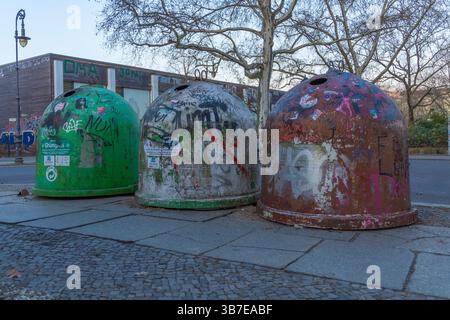 Drei kuppelförmige Recyclingbehälter in Berlin, bedeckt mit Graffiti und Street Art. Urbane Szene, die das Leben in der Stadt, die Abfallwirtschaft und das düstere A widerspiegelt Stockfoto