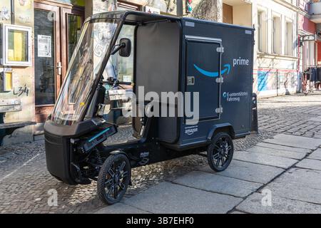 Elektrisches Amazon Prime-Lieferdreirad parkt auf einer Kopfsteinpflasterstraße in Berlin und präsentiert nachhaltige städtische Logistik und moderne E-Mobility-Lösungen Stockfoto