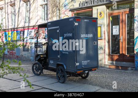 Elektrisches Amazon Prime-Lieferdreirad parkt auf einer Kopfsteinpflasterstraße in Berlin und präsentiert nachhaltige städtische Logistik und moderne E-Mobility-Lösungen Stockfoto