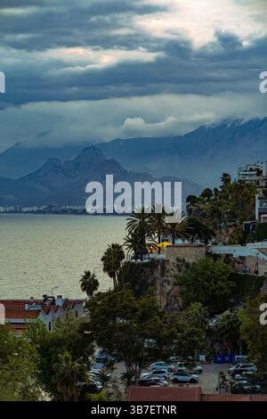 Ein malerischer Blick auf die Küste von Antalya, Türkei, mit dramatischen Wolken über dem Taurusgebirge und dem Mittelmeer. Stockfoto