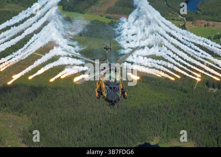 Der NHI NH90 TTH der finnischen Armee, die NH-205, setzt während des Flugbetriebs über Finnland Flares aus. Dieser Multifunktionshubschrauber ist für Transport, Truppeneinsatz und taktische Missionen ausgerüstet und für seine Vielseitigkeit in verschiedenen militärischen Umgebungen bekannt. Stockfoto