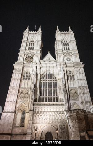 Die Westminster Abbey steht majestätisch am Nachthimmel in London. Die komplizierte Architektur und die hohen Türme werden hervorgehoben und bieten eine atemberaubende Aussicht für die Abendbesucher. Stockfoto