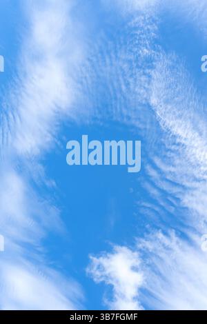 Der niedrige Winkel des schönen blauen Himmels mit der seltsamen Form flauschiger weißer Wolken am Morgen oder Abend bei sonnigem Tag wird als natürlicher Hintergrund verwendet. Stockfoto