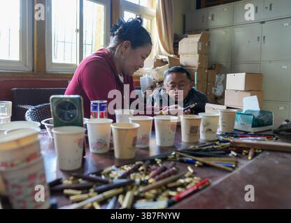 (250506) -- LHASA, 6. Mai 2025 (Xinhua) -- Lhapa Dondrup spricht mit einem Kollegen des Unternehmens in Lhasa, der autonomen Region Xizang im Südwesten Chinas, am 5. Mai 2025 über den Plan für das Produktschießen. Lhapa Dondrup, ein 24-jähriger Mann, der in Lhasa geboren wurde, leidet seit seiner Kindheit an Osteogenesis imperfecta (OI), allgemein bekannt als brüchige Knochenerkrankung. Als Erwachsener steht er unter einem Meter groß und verlässt sich auf Krücken und elektrischen Rollstuhl für Mobilität. Trotz dieser Herausforderungen träumt Lhapa davon, Fotograf zu werden. 2021 trat er einem von individ gegründeten Kulturmedienunternehmen bei Stockfoto