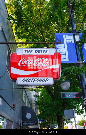 Das klassische Coca Cola-Schild „The Drive Skateshop“ entlang des Commercial Drive in Vancouver, BC. Stockfoto