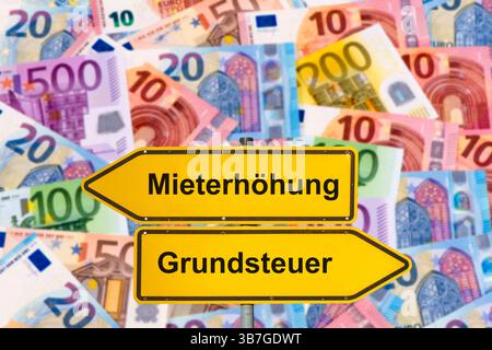 Mieterhöhung wegen Grundsteuer ein Wegweiser mit dem Aufdruck Mieterhöhung und Grundsteuer steht vor vielen Euro Geldschainen - FOTOMONTAGE *** Rent i Stockfoto