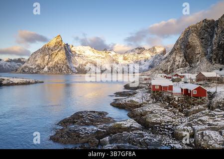 Rorbuer Fischerhütten vor schneebedeckten Bergen im Winter, Hamnoy, Moskenesoy, Lofoten, Norwegen, Europa Stockfoto
