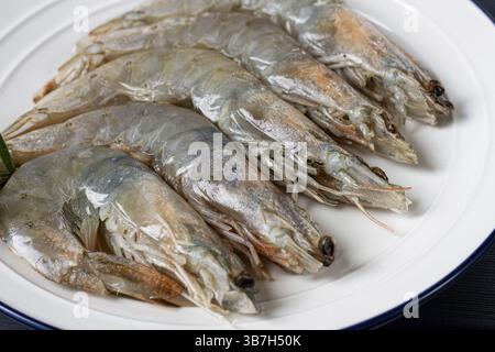 Frische rohe Weißfußgarnelen, Tigergarnelen vannamei, auf einem weißen Teller Stockfoto