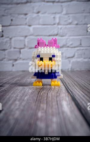 Daisy Ente Nanoblock Figur steht auf Holzoberfläche Stockfoto