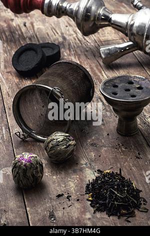 Details Wasserpfeife und trockene Elite-Teeblätter auf hölzernem Hintergrund. Das getönte Bild Stockfoto