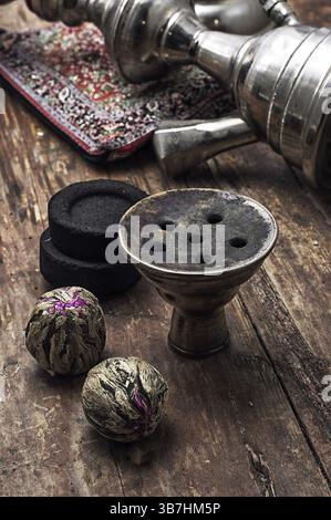 Details Wasserpfeife und trockene Elite-Teeblätter auf hölzernem Hintergrund. Das getönte Bild Stockfoto