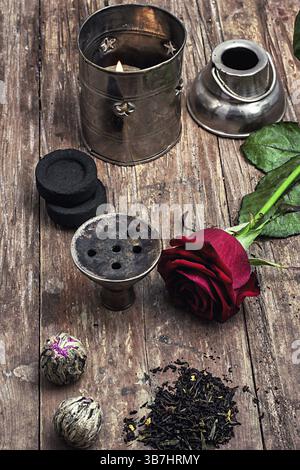 Details Wasserpfeife und trockene Elite-Teeblätter auf hölzernem Hintergrund. Das getönte Bild Stockfoto