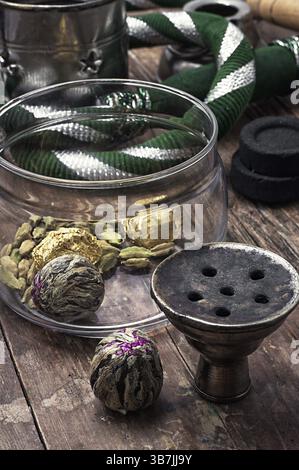 Details Wasserpfeife und trockene Elite-Teeblätter auf hölzernem Hintergrund. Das getönte Bild Stockfoto