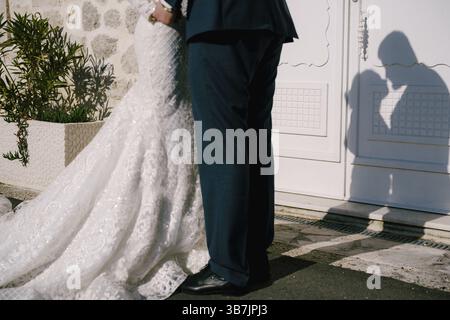 Schatten von fast küssenden Braut und Bräutigam an der Tür des Steinhauses. Nahaufnahme. Stockfoto