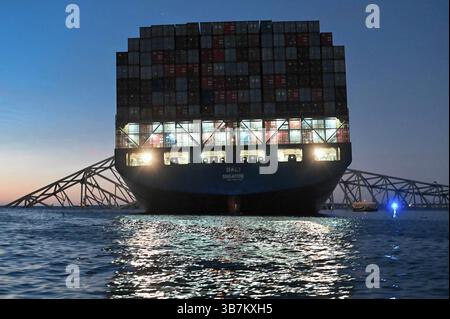 26. März 2024, Dundalk, MD, Vereinigte Staaten von Amerika: Der verschlungene Frachtträger MV Dali, ummantelt in den Stahlträgern der gestürzten Francis Scott Key Bridge, blockiert den Kanal Fort McHenry, 26. März 2024, nahe Dundalk, Maryland. Die Brücke wurde am 26. März von einem 984-Fuß-Containerschiff getroffen und stürzte zusammen, wobei sechs Arbeiter ums Leben kamen. (Bild: © Po3 Carmen Caver/US Coast/Planet Pix via ZUMA Press Wire) Stockfoto