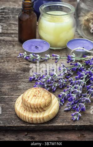 Kerzen, Blumen Lavendelöl für Spa-Behandlungen auf hölzernem Hintergrund. Foto getönt. Selektiver Fokus Stockfoto