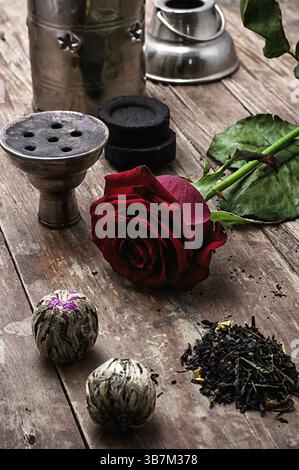 Details Wasserpfeife und trockene Elite-Teeblätter auf hölzernem Hintergrund. Das getönte Bild Stockfoto