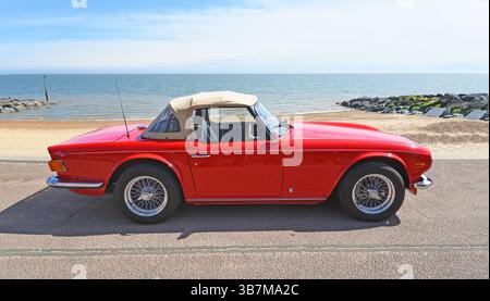 Klassischer Triumph TR6 Motor Car am Strand und Meer im Hintergrund Stockfoto