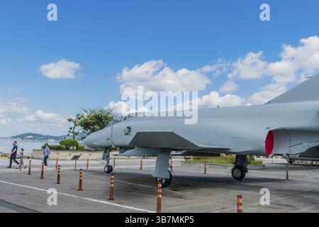Seosan, Südkorea. 13. September 2020: F-4 Phantom Jagdjet im Park am Meer unter blauem Himmel, an dem Touristen vorbeispazieren gehen Stockfoto