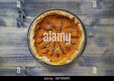 Kürbiskuchen mit Sardellen in einer Glasschale steht auf einem Holztisch. Draufsicht. Stockfoto