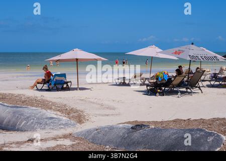 Holbox, Mexiko – 9. Februar 2025: Touristen entspannen sich unter Sonnenschirmen auf dem weichen Sand von Holbox Stockfoto