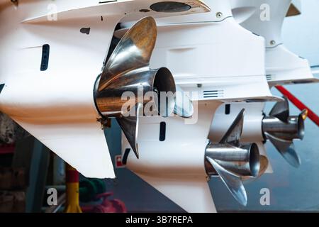 Motorpropeller für Motoryachten und Boote in Nahaufnahme. Die Motoren sind am Heck des Motorbootes montiert. Reparieren Sie ein Boot in einem Trockendock. Stockfoto