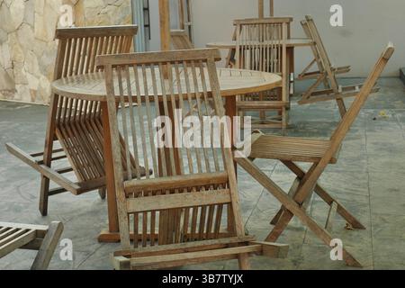 Klappstuhl aus Holz, der verblasst aussieht, weil er im Außenbereich aufgestellt wird Stockfoto