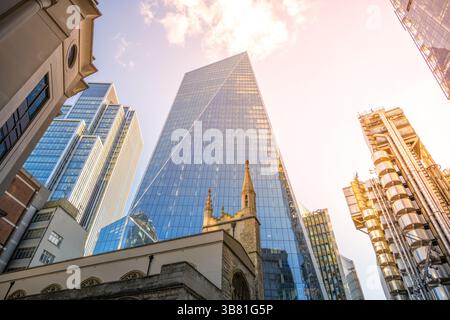 Die St. Andrew Undershaft Church steht vor hoch aufragenden modernen Wolkenkratzern im Herzen von Londons Finanzviertel und zeigt die Mischung aus Geschichte und zeitgenössischer Architektur. Stockfoto
