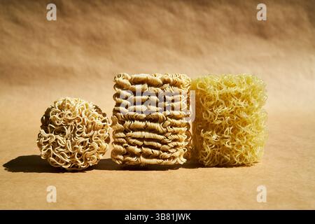 Verschiedene trockene Instant-Nudelblöcke auf braunem Hintergrund. Lebensmittelkonzept Stockfoto