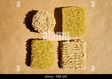 Verschiedene trockene Instant-Nudelblöcke auf braunem Hintergrund. Lebensmittelkonzept Stockfoto