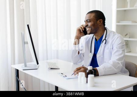 Glücklicher schwarzer Arzt, der mit dem Patienten telefoniert Stockfoto