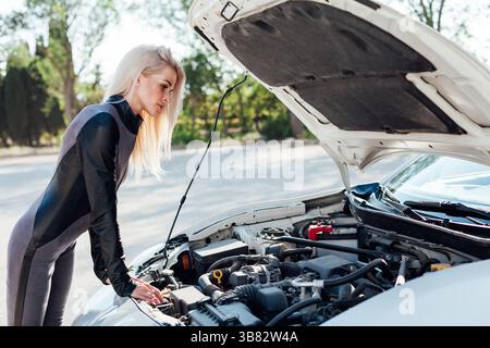 Weibliche Automechanikerin repariert Automotor in der Garage Stockfoto