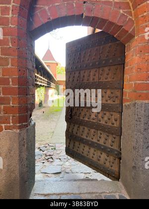 Eine alte Holztür öffnet sich zum Burghof. Stockfoto