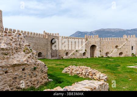 Historische mittelalterliche Burgruinen mit grünem Gras und Steinbogenmauern Stockfoto