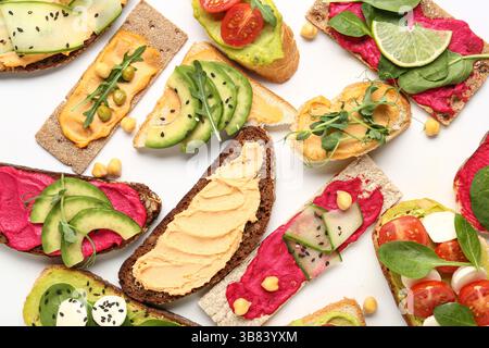 Auswahl an verschiedenen Sandwiches mit Hummus, Käse und Gemüse auf weißem Hintergrund Stockfoto