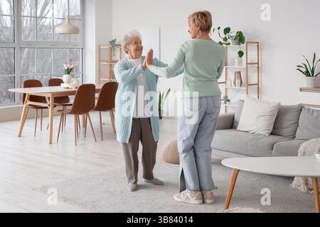 Reife Frau mit ihrer Mutter, die zu Hause tanzt Stockfoto