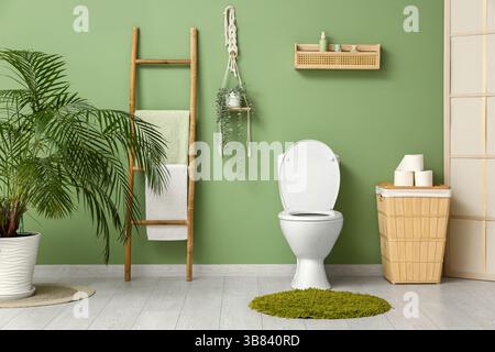 Das Innere des stilvollen Toiletten mit Keramikschale, Papierrollen und Korb Stockfoto