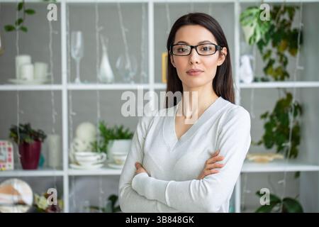 Selbstbewusste Frau mit überkreuzten Armen im Büro Stockfoto