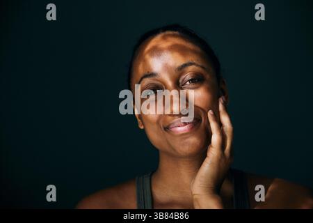 Porträt einer lächelnden Frau mit Hand auf Wange Stockfoto