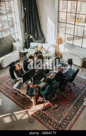 Hochwinkelansicht fokussierter multirassischer Softwareentwickler, die am Schreibtisch im Technikzentrum arbeiten Stockfoto