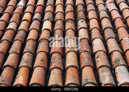 Die Textur der alten braunen Schindeln auf dem Dach des Gebäudes. Stockfoto
