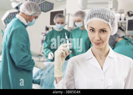 Junge weibliche Anästhesist mit Spritze auf die Chirurgie wimmeln Hintergrund Stockfoto