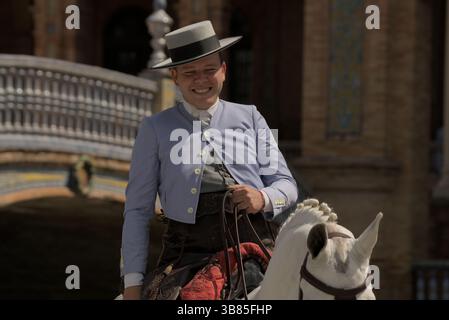 Lächelnder andalusischer Reiter im traditionellen Traje corto zu Pferd während der Feria de Sevilla 2025, Sevilla, Andalucía, Spanien. Stockfoto