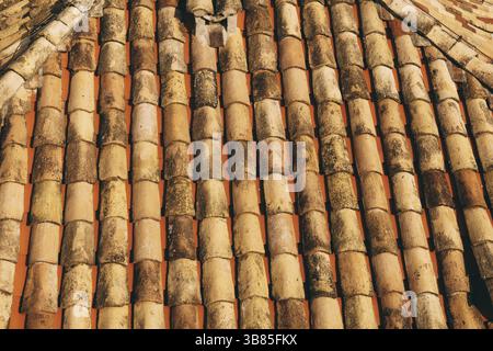 Die Textur der alten braunen Schindeln auf dem Dach des Gebäudes. Stockfoto